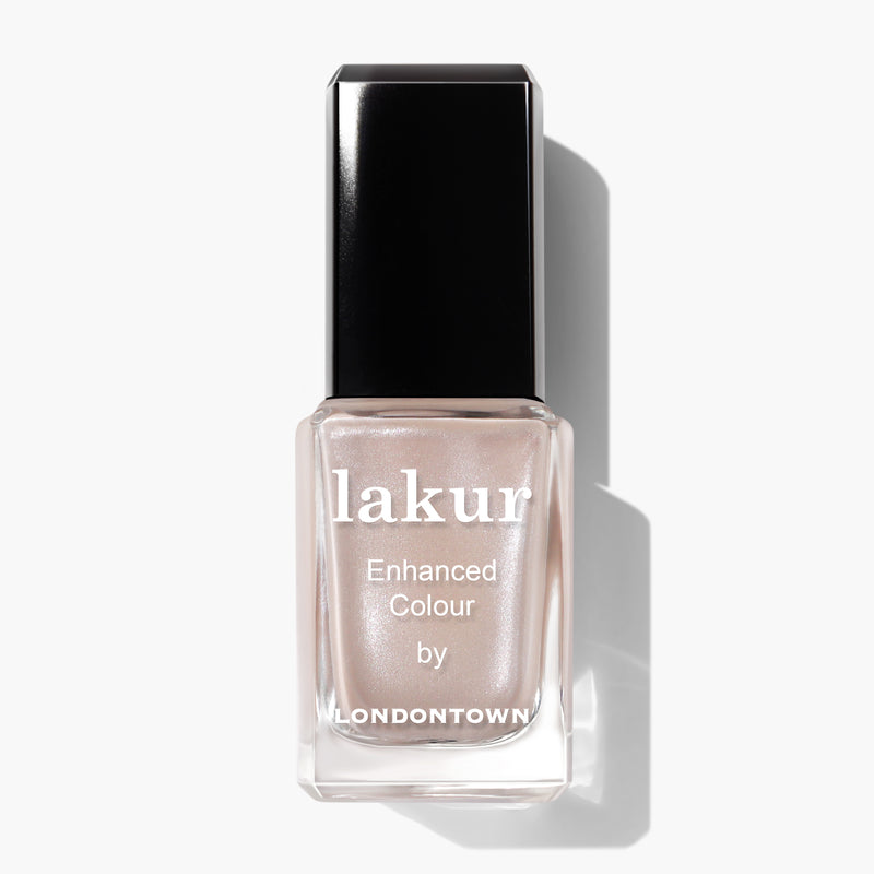 A bottle of LONDONTOWN's Lakur enhanced color nail polish in the soft, neutral shade of Pearl, with a shimmering champagne touch, set against a white background.