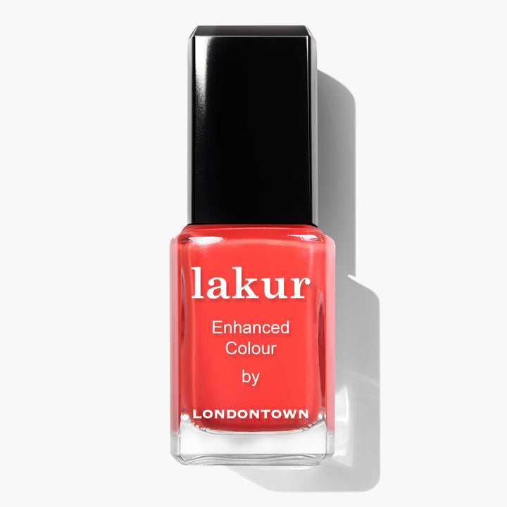 A bottle of Piccadilly Square nail polish by LONDONTOWN, featuring an ultra-bright blood orange crème color with a black cap, on a white background. This vegan and cruelty-free nail polish delivers both style and conscience.