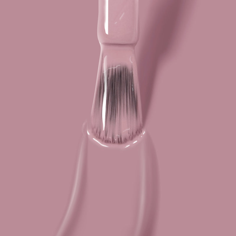 A close-up shot of a nail polish brush applying LONDONTOWN's Plush, a mauve crème shade of pink vegan nail polish.