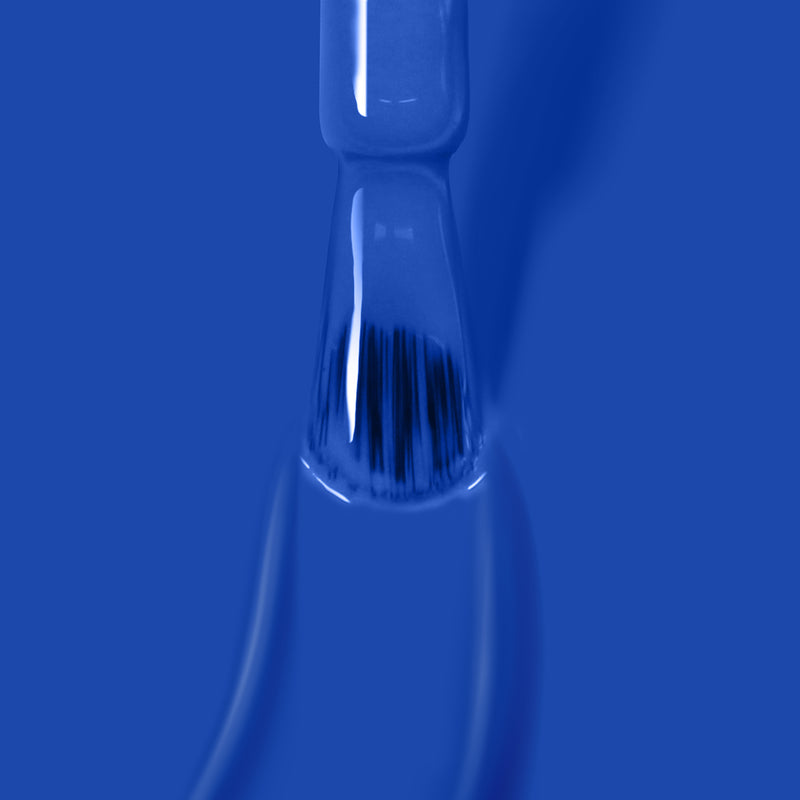 Close-up of a LONDONTOWN Poolside Dreams gel color nail polish brush coated in blue against a matching blue background.