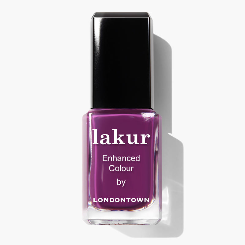 A bottle of Portobello Plum nail polish by LONDONTOWN. This bottle is filled with a deep warm plum crème nail polish and features a black cap. The vegan and cruelty-free nail polish from the Lakur Enhanced Colour line adds a touch of sophistication to any style.