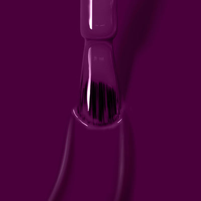 Close-up of a nail polish brush dipped in Portobello Plum (Professional), a deep warm crème by LONDONTOWN, with the rich, vegan cruelty-free nail polish pooling around the tip.