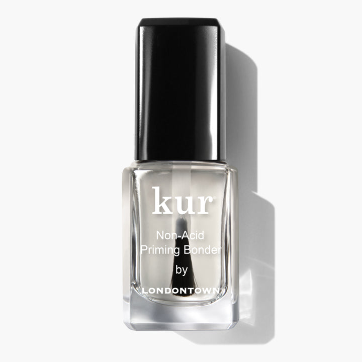 A bottle of "Non-Acid Priming Bonder by LONDONTOWN" featuring a black cap, photographed against a white background—a pro secret for long-lasting manis.