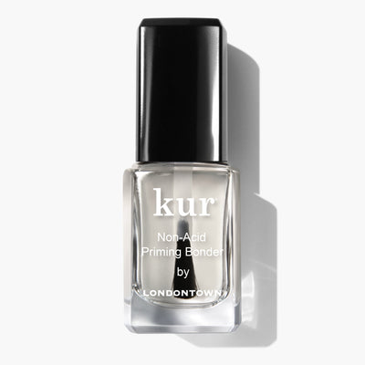 A clear bottle of Non-Acid Priming Bonder (Professional) by LONDONTOWN, the secret to long-lasting manicures, with a black cap, displayed on a white background.
