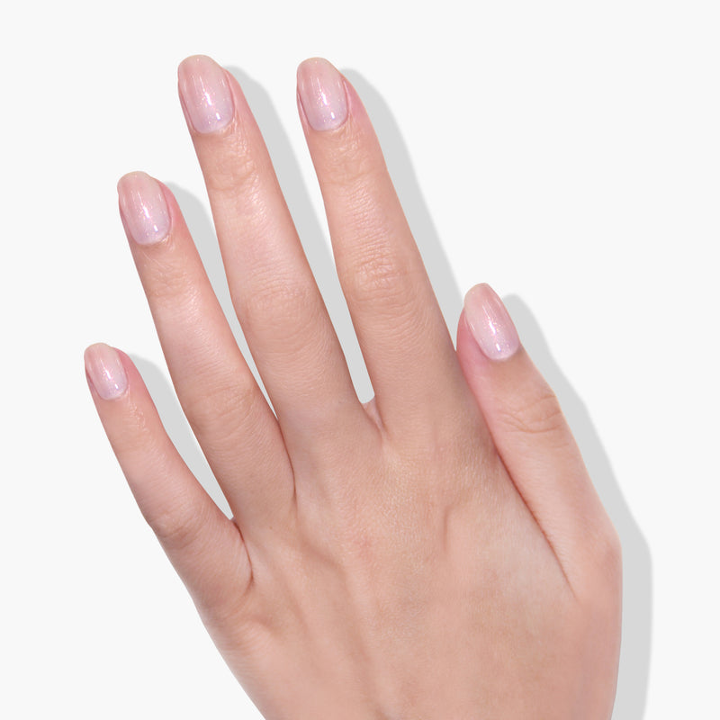 A left hand with short, neatly filed nails painted with "Princess Awaits," a light pink, shimmery gel polish by LONDONTOWN, displayed against a white background.