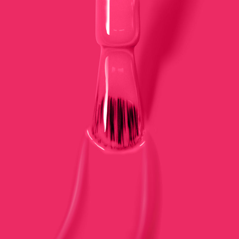Close-up image of a nail polish brush with deep fuchsia pink crème on it, against a matching pink background. This vegan, cruelty-free polish from LONDONTOWN’s Queen of Hearts collection ensures a flawless, guilt-free manicure.