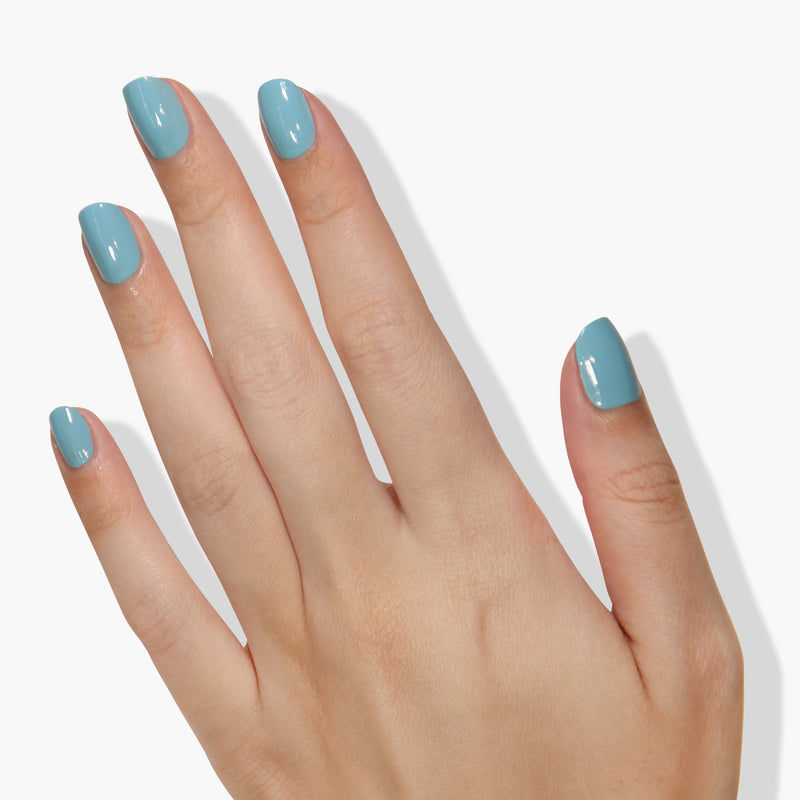 A hand with "Reverse the Charges" blue cruelty-free nail polish by LONDONTOWN on its nails, shown against a white background.