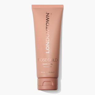 A 104ml tube of LONDONTOWN's Rose Gold Hand Peel featuring a pinkish-brown cap and label. The packaging displays the text "Peel & Serum." This transformative mask promises brighter, softer hands.