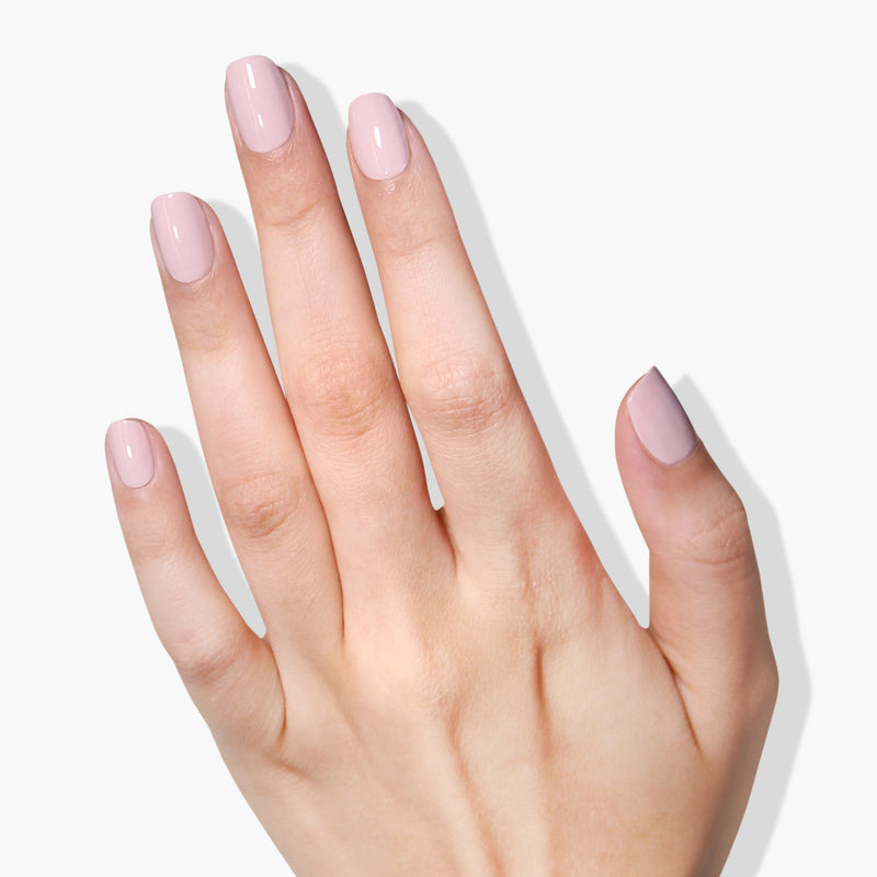 A hand with neatly manicured nails painted in Rosewater, a light pink color from LONDONTOWN's high-shine formula, against a plain white background.