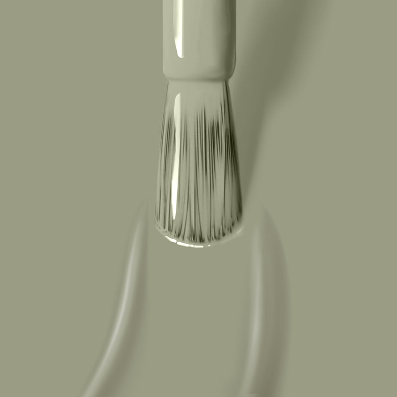 Close-up of a paintbrush applying succulent jade green **Sedona** paint by **LONDONTOWN**, with brush bristles slightly spread.