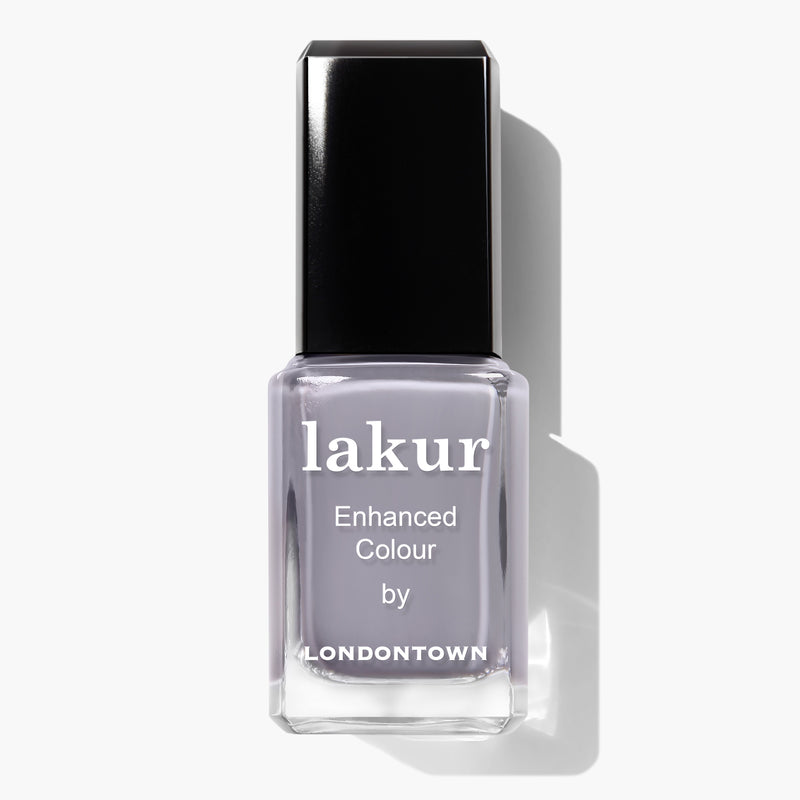 A bottle of LONDONTOWN's Lakur Enhanced Colour vegan nail polish in the shade "Silver Birch," featuring a light grey hue and a black cap. This cruelty-free product ensures your manicure is as kind to animals as it is chic.