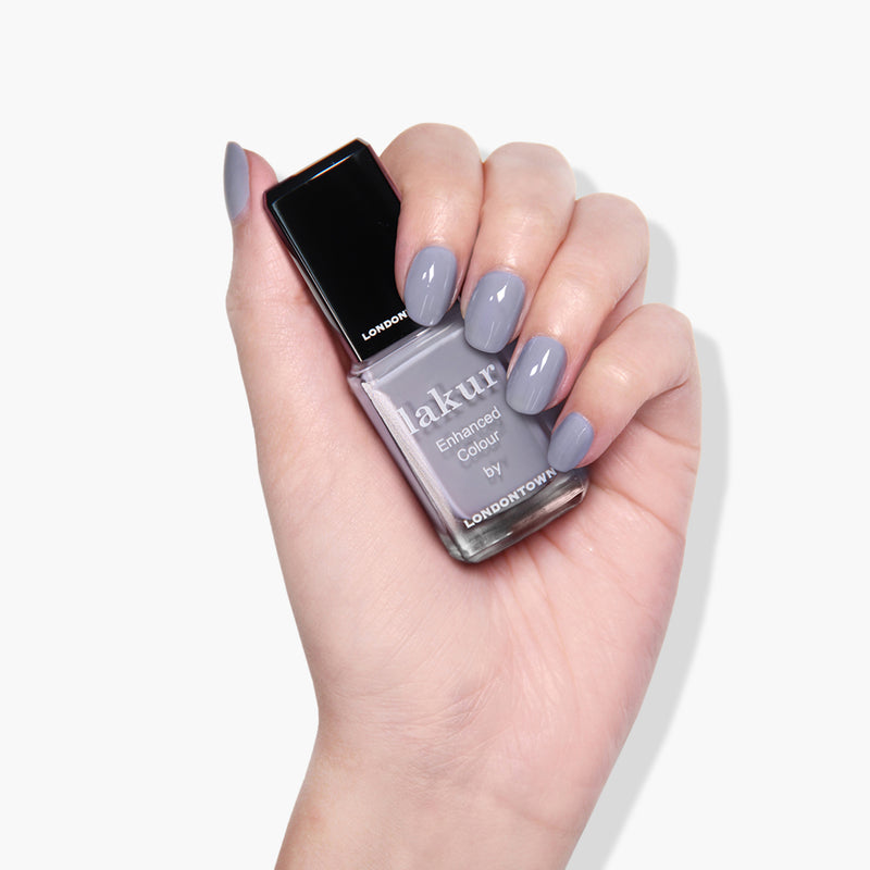 A hand holding a bottle of LONDONTOWN's Silver Birch vegan and cruelty-free nail polish.
