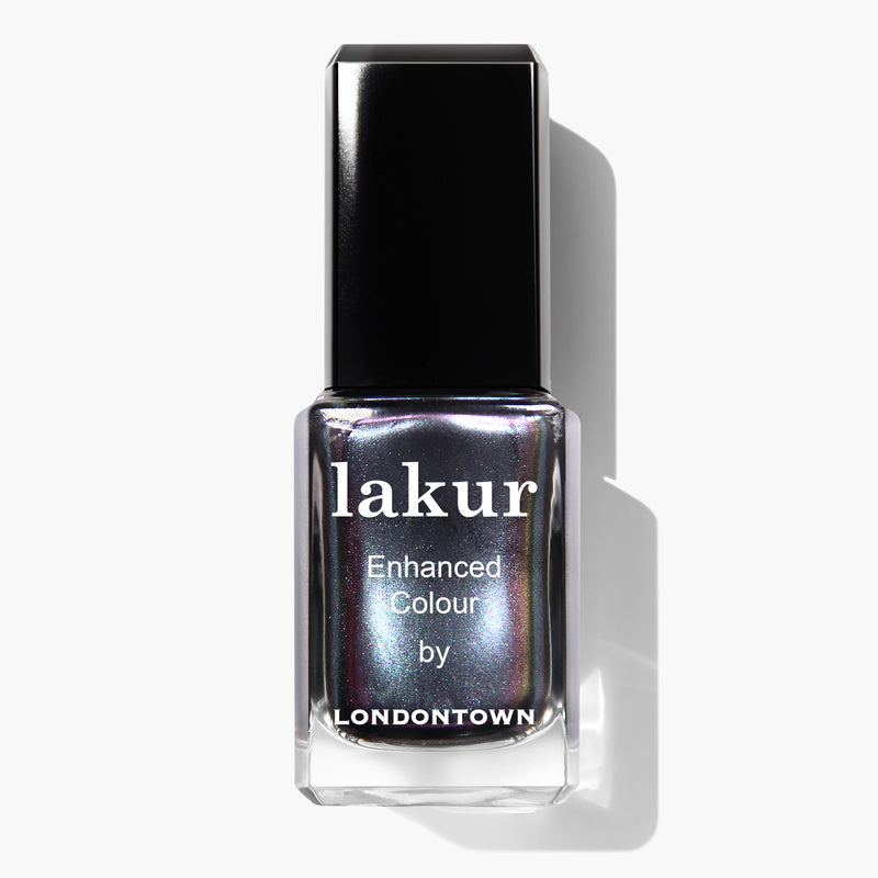 A bottle of LONDONTOWN Lakur Enhanced Colour nail polish named Skyline Reflect, featuring a black cap and a shimmery metallic finish in silver.