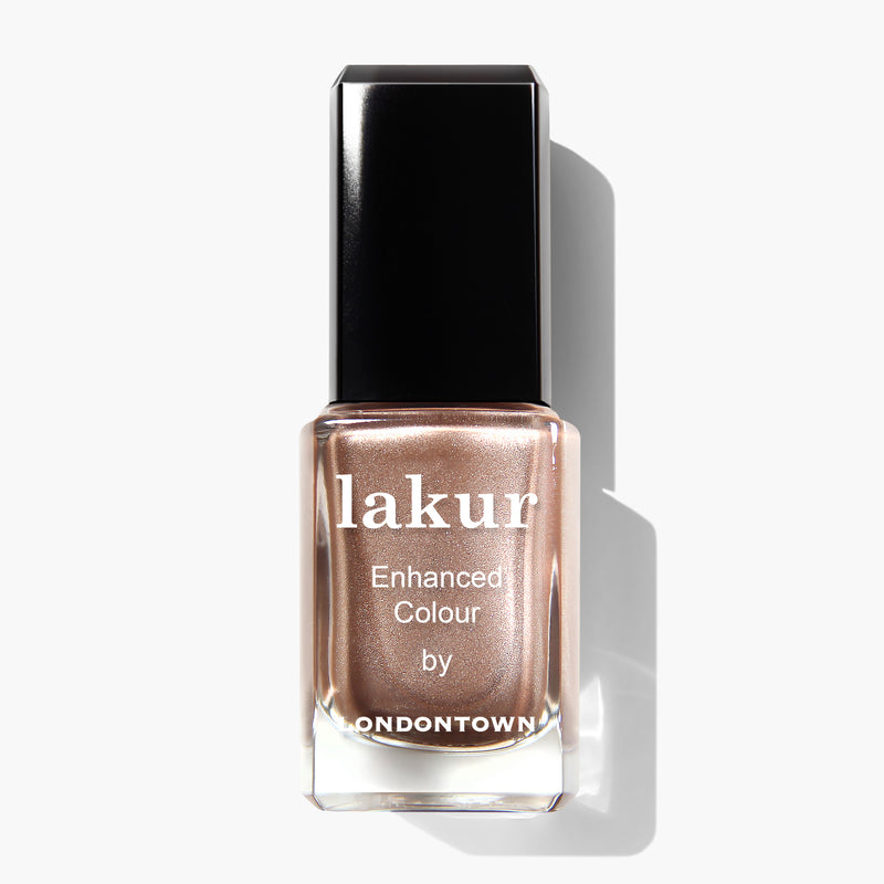 A bottle of LONDONTOWN vegan nail polish in the cruelty-free, metallic nude shade "Sugarcane" with a black cap, labeled "Enhanced Colour.