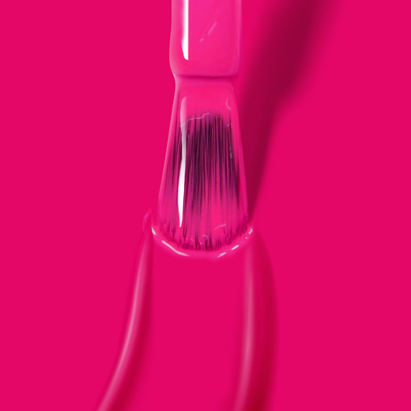 Close-up of a brush applying a shocking pink shade of LONDONTOWN's Summer Fling gel color, ready to be cured under UV/LED light.