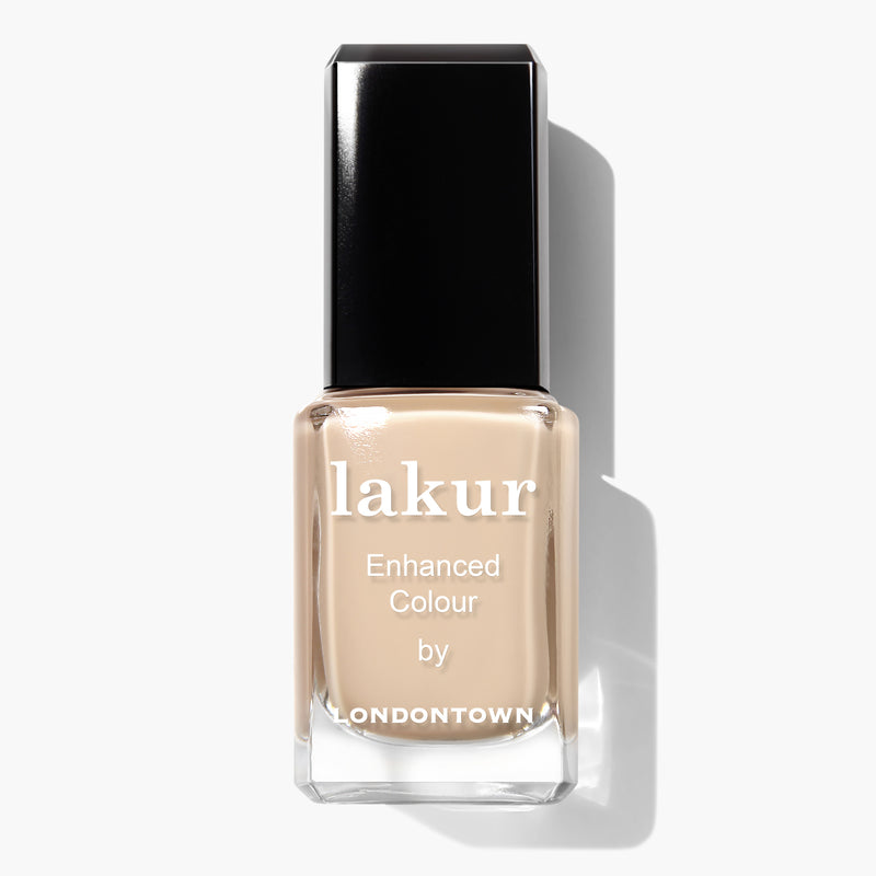 Bottle of LONDONTOWN Lakur nail polish in the shade "Teatime," featuring a sheer barely-there nude color, text on the front that says "lakur Enhanced Colour by LONDONTOWN," and proudly labeled as cruelty-free.