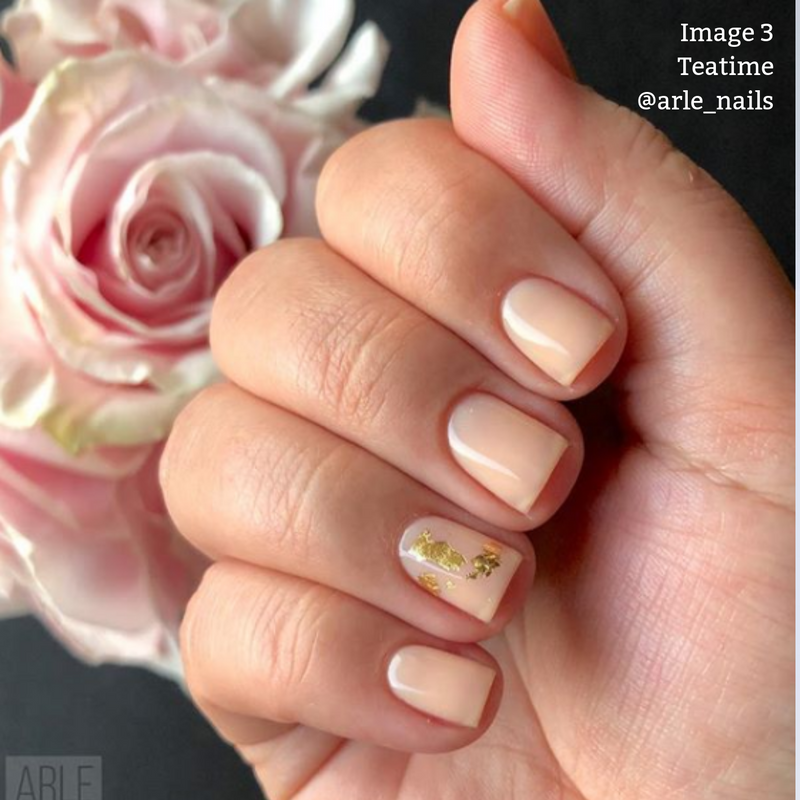 A neatly manicured hand with sheer, barely-there nude nails featuring a small gold foil accent on the ring finger. A light pink rose is in the background. The text reads: "Image 3 Teatime by LONDONTOWN @arle_nails.”
