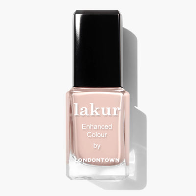 A bottle of LONDONTOWN's nail polish named "Uncovered (Professional)" in a neutral beige shade, featuring a black cap and casting a shadow to the right.