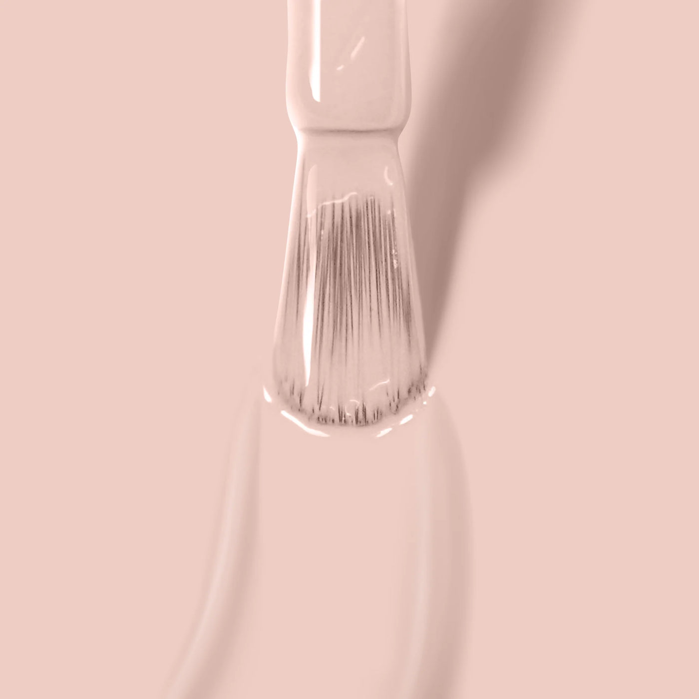 Close-up of a paintbrush applying LONDONTOWN's Uncovered (Professional) light beige polish on a surface.