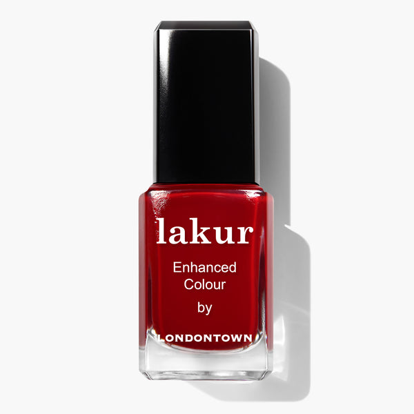 A bottle of Vendetta nail polish from LONDONTOWN, in deep scarlet red with a black cap, casting a shadow to the right. This cruelty-free and vegan formula ensures you can look stylish while making ethical choices.
