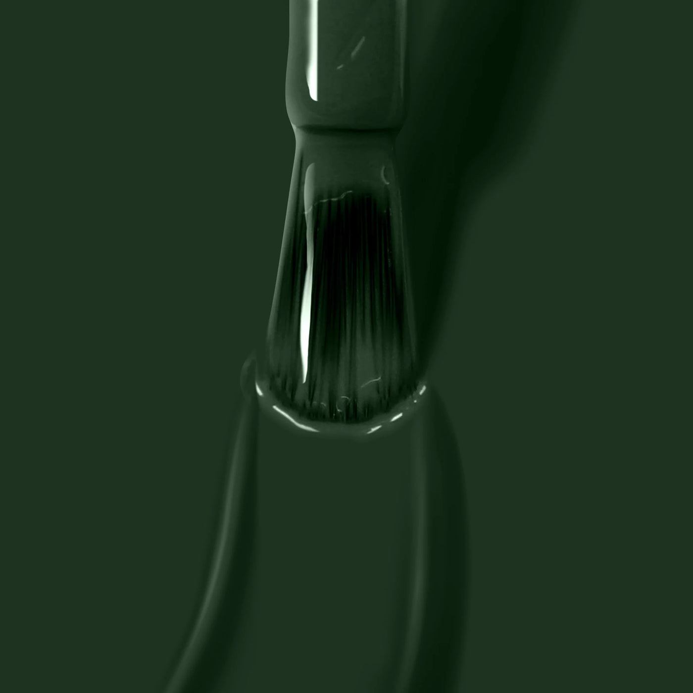 Close-up of a LONDONTOWN Vibe (Professional) paintbrush covered in jade green paint, positioned vertically with bristles partially immersed in the vibrant hue.