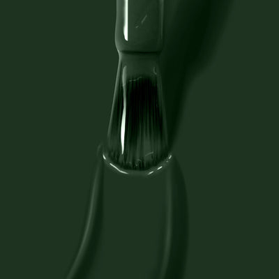 Close-up of a LONDONTOWN Vibe (Professional) paintbrush covered in jade green paint, positioned vertically with bristles partially immersed in the vibrant hue.