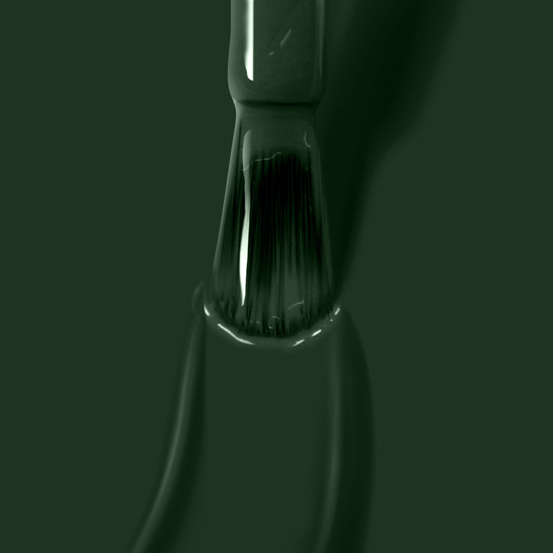 A close-up of a LONDONTOWN Vibe paintbrush bristle coated in jade green paint, with paint dripping off the brush like melted licorice.