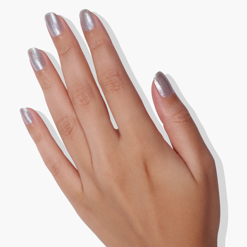 A hand with LONDONTOWN's Whipped Blueberry nail polish and ultrafine glitter on the fingernails is shown against a white background.