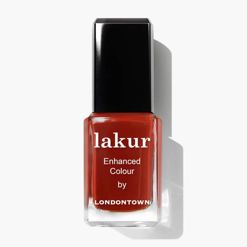 A bottle of LONDONTOWN's Lakur nail polish in the sophisticated rich red-brown shade named Woodstock. The rectangular bottle features a black cap and white text on the front.