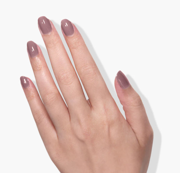 A hand with neatly manicured nails painted in a glossy, dusty pink UV/LED Gel Color named "Bell Flower" by LONDONTOWN is positioned against a plain white background.